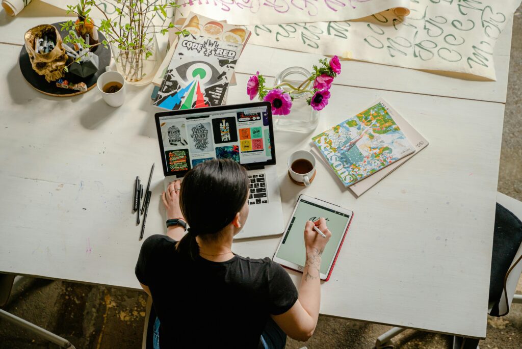 alt="Beginner-friendly Adobe Express interface for graphic design"Artistic workspace featuring calligraphy and digital design on a tablet and laptop.