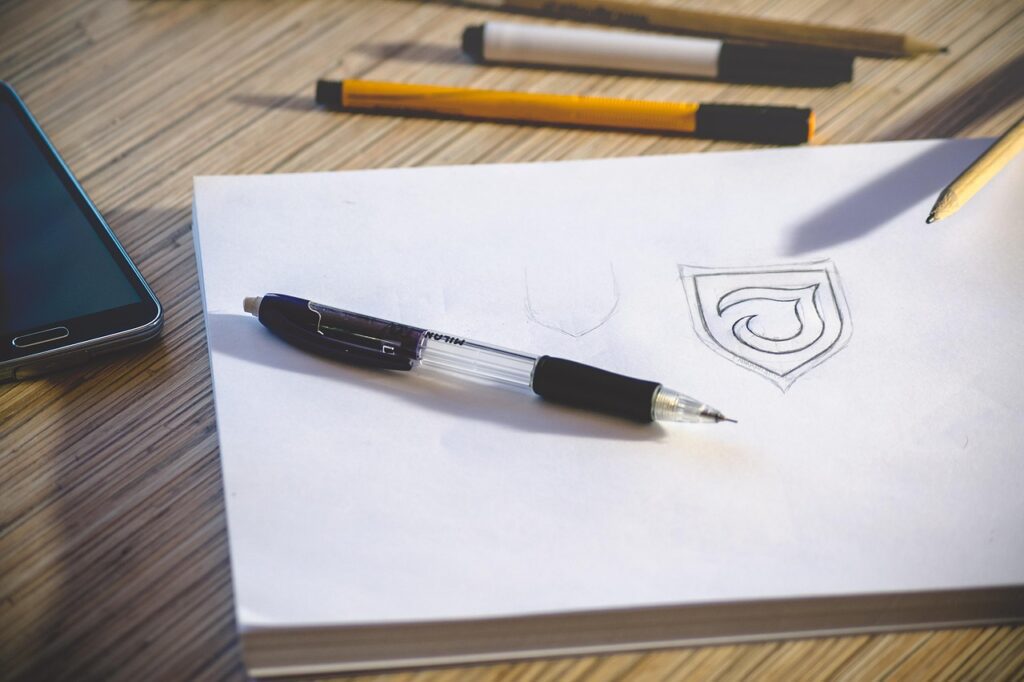 alt="consistent brand identity logo design for small businesses"desk, workspace, pencil, paper, logo, sketch, work, office, office desk, workplace, table, document, notebook, drawing, designing, pens, white paper, logo, logo, logo, logo, logo