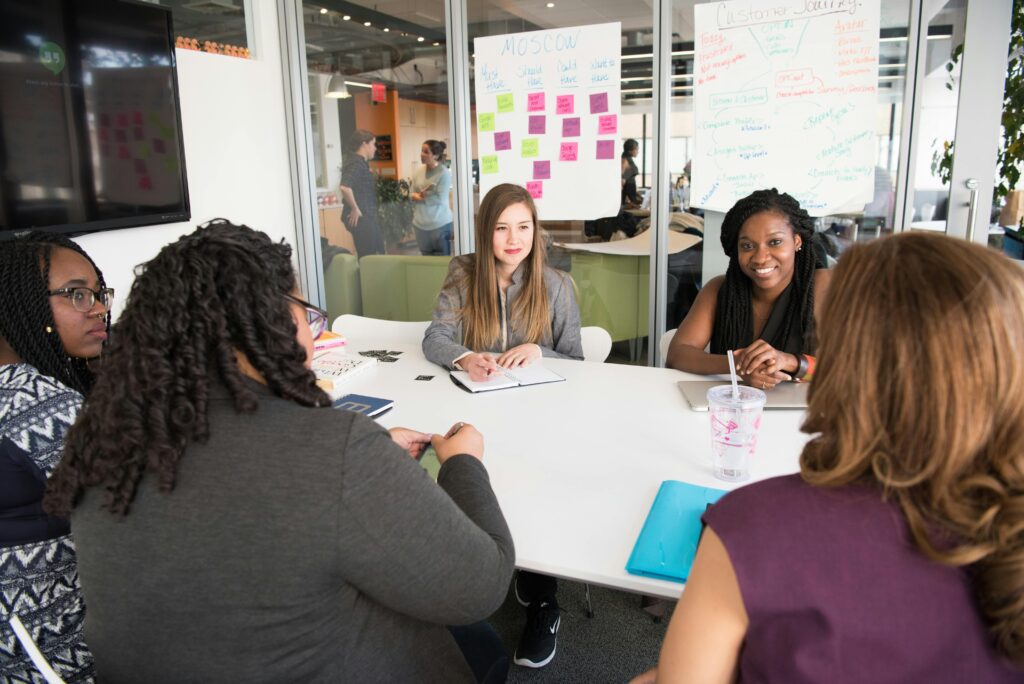 A diverse group of women collaborating in a modern conference room setting.
