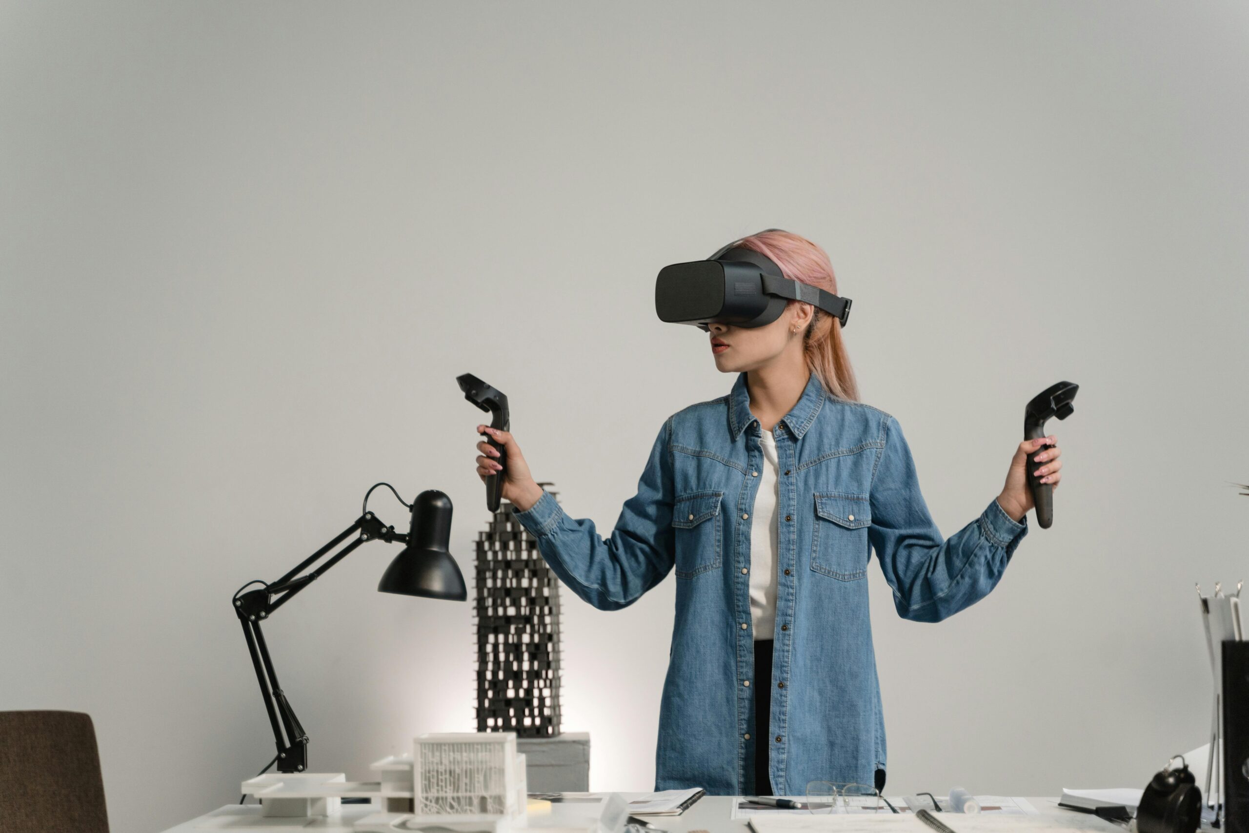 Young woman using virtual reality for architectural design in a modern office setting.