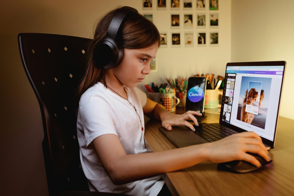 pexels photo 17771092 17771092 A focused young girl wearing headphones works on a creative project using a laptop and design software.