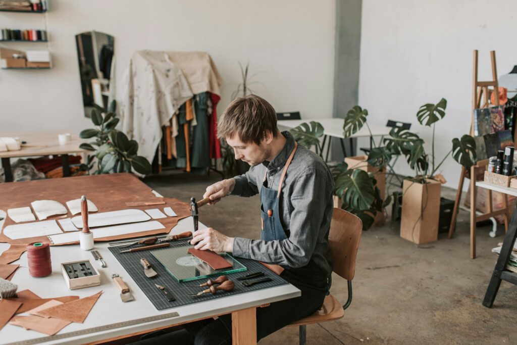 pexels photo 4452633 4452633 Leather craftsperson working at a table in a stylish workshop.