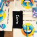 Optimize brand kits in Canva for low energy visuals 2026:Flat lay of Canva Community Labs merchandise with vibrant design and branding elements.