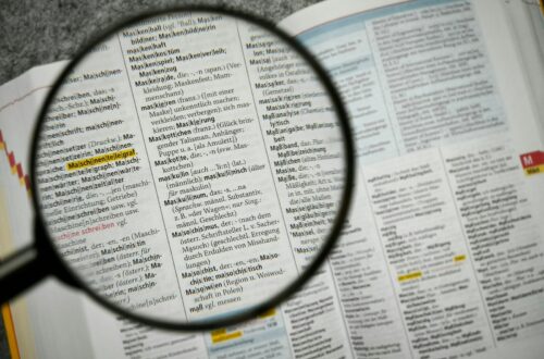 Keyword research tools Magnifying glass focuses on a dictionary page.
